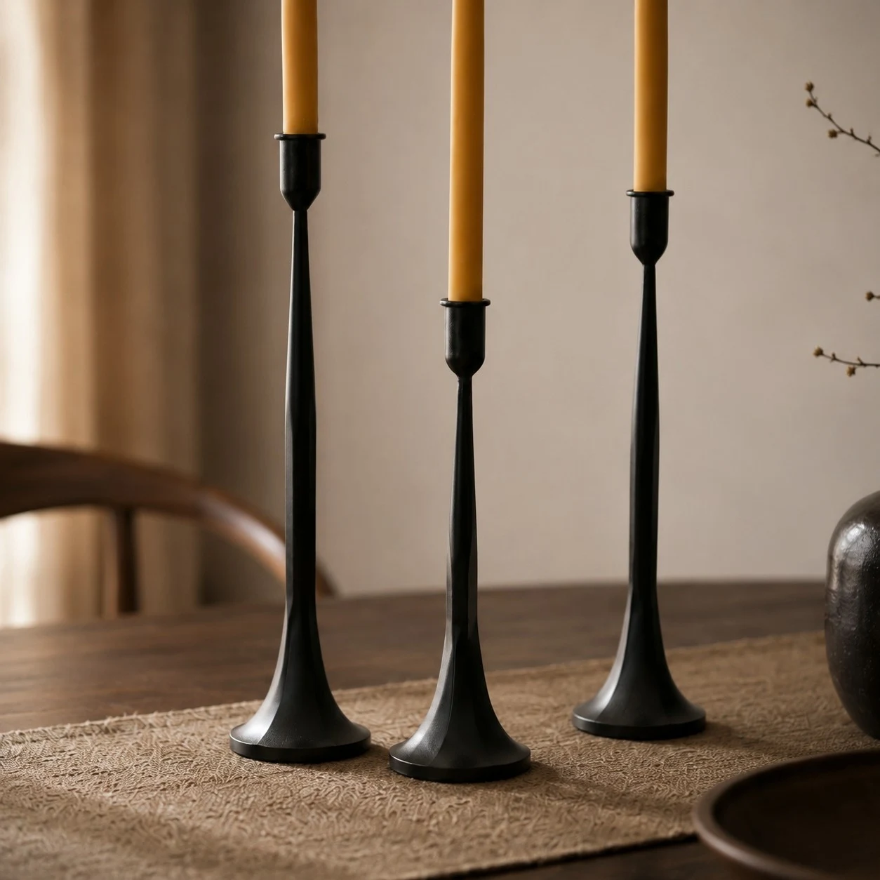 Three black iron taper candle holders showing varied height and slim stems