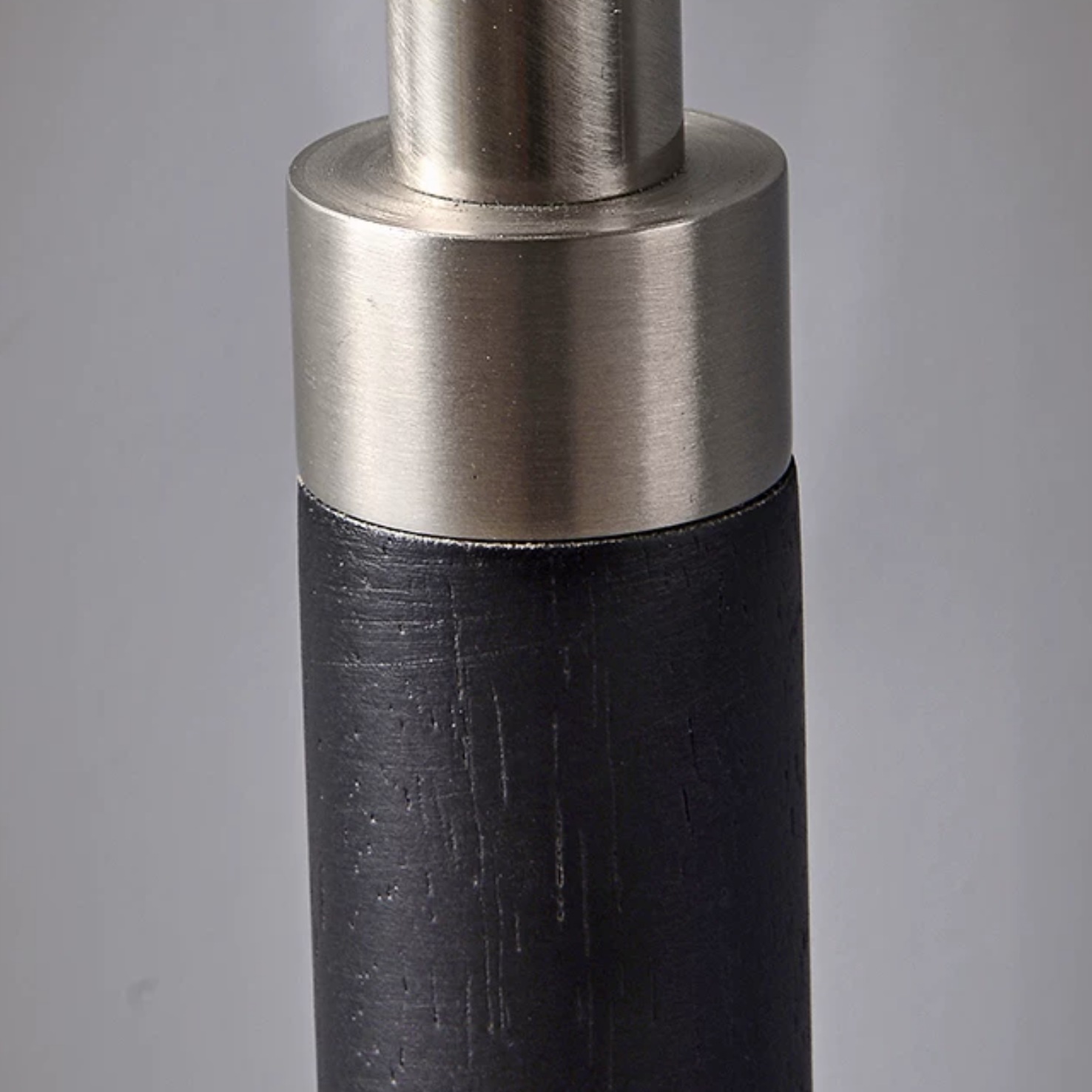 Black solid wood floor lamp stem with a brushed chrome joint