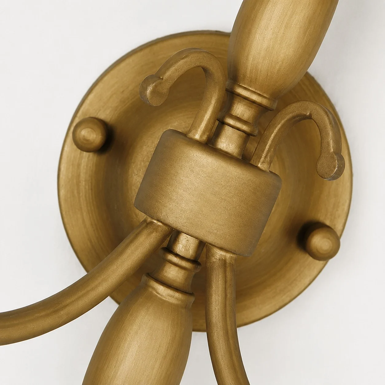 Antique brass wall plate and curved arm detail