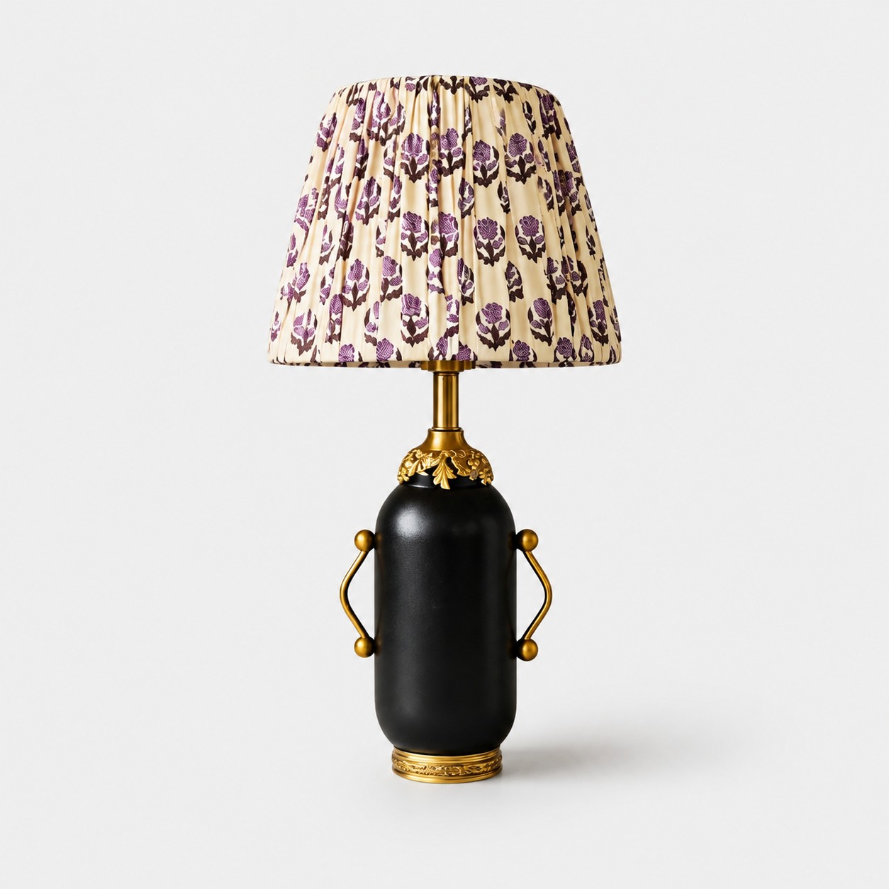 Matte black vintage table lamp with purple floral pleated shade on white background