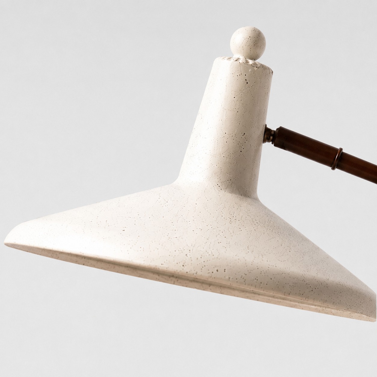 Close-up of textured ivory metal lampshade and rounded top finial